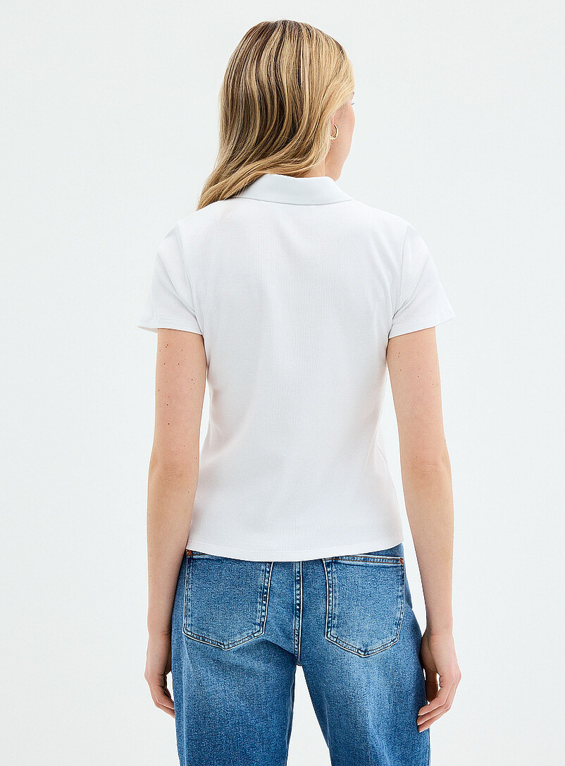 Contemporaine: Le polo c&ocirc;tel&eacute; ajust&eacute; uni Noir pour femme
