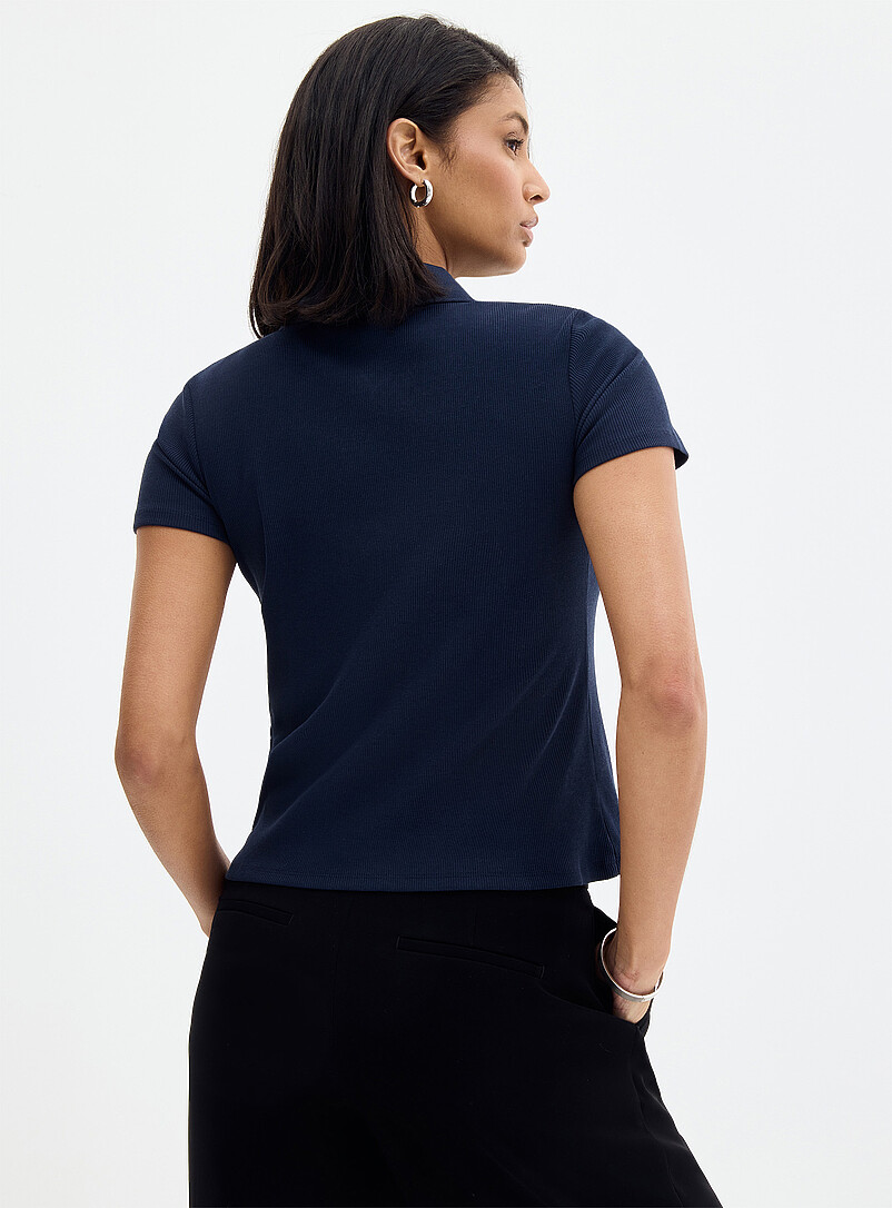 Contemporaine: Le polo c&ocirc;tel&eacute; ajust&eacute; uni Noir pour femme