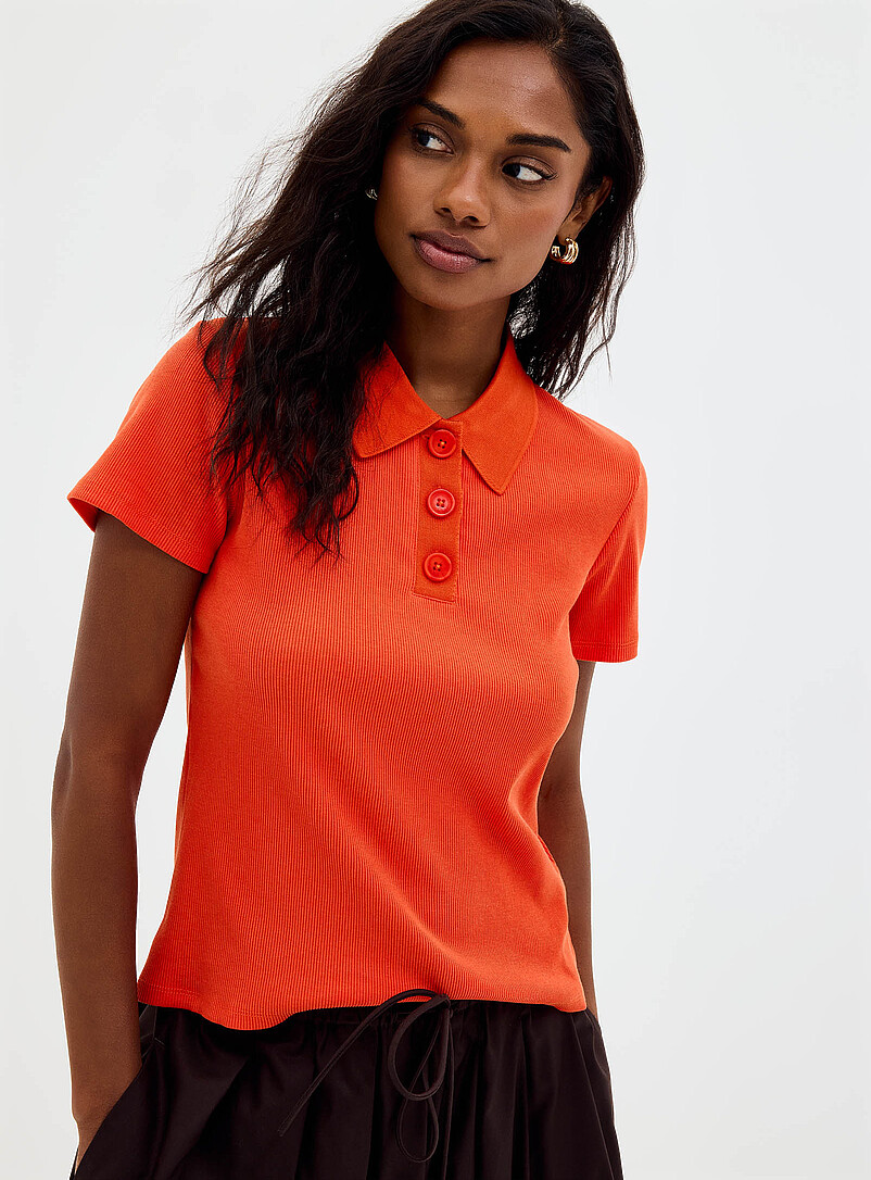 Contemporaine: Le polo c&ocirc;tel&eacute; ajust&eacute; uni Noir pour femme
