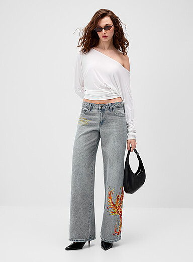 Rhinestone phoenix baggy jean Fit: Wide-leg, low-rise