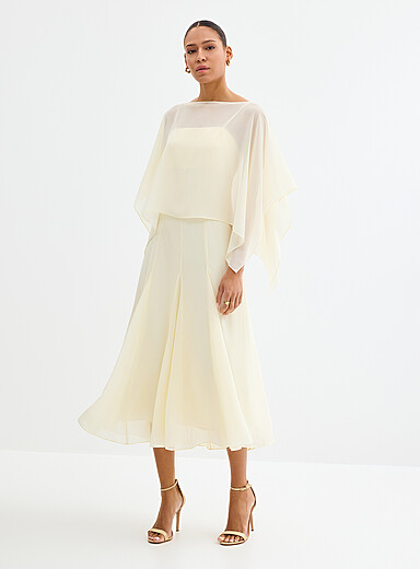 La longue robe fluide blanc vanille avec cape