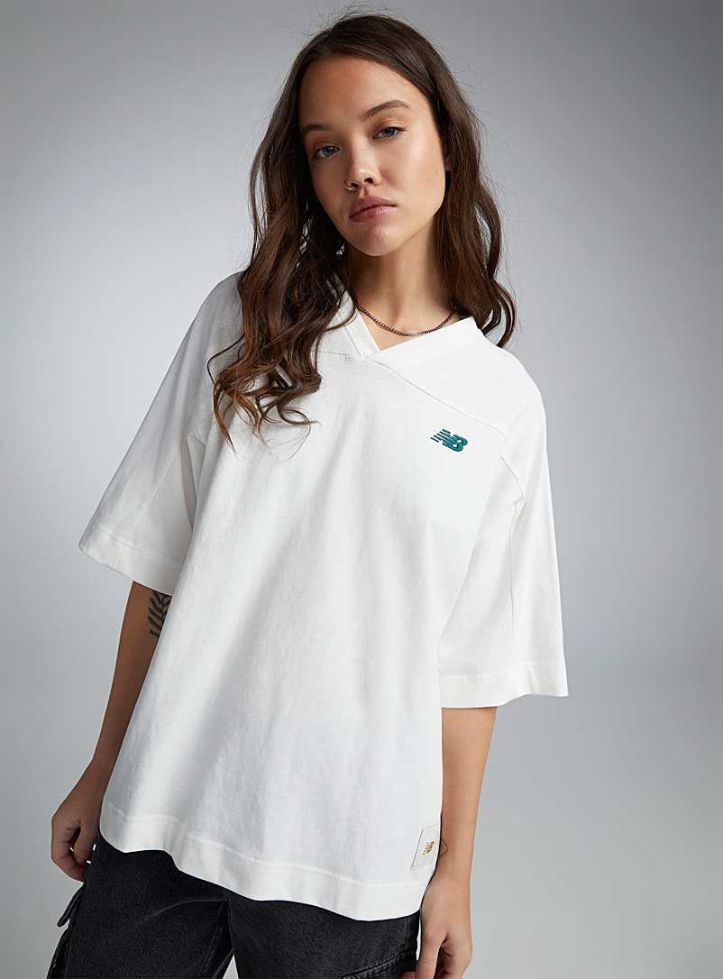 New Balance: Le t-shirt col V à numéro Beige crème pour femme
