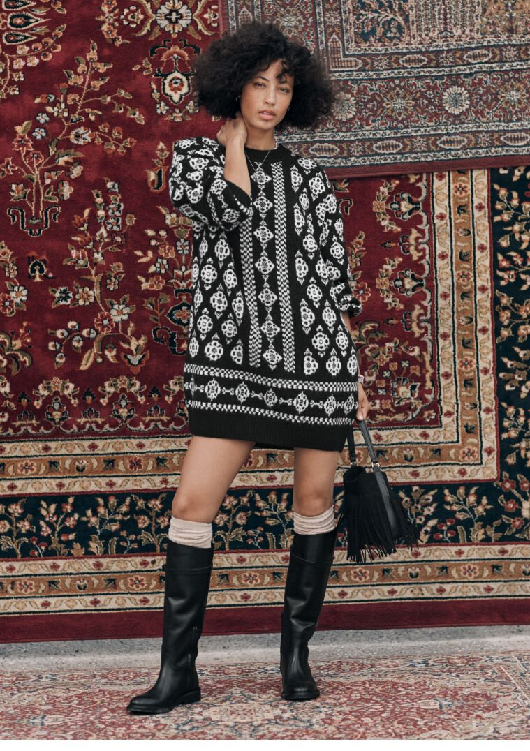 Femme portant une robe en tricot jacquard à motifs folkloriques et bottes noires montant aux genoux