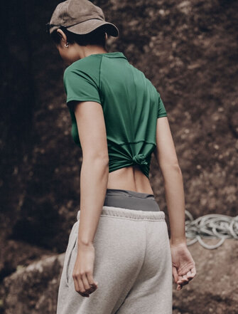 Woman wearing a green T-shirt, walking in nature