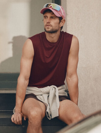Homme assis à l'extérieur portant un T-Shirt rouge sans manches