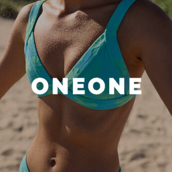 Une femme sur la plage portant un maillot deux-pièces au motif floral de la marque OneOne
