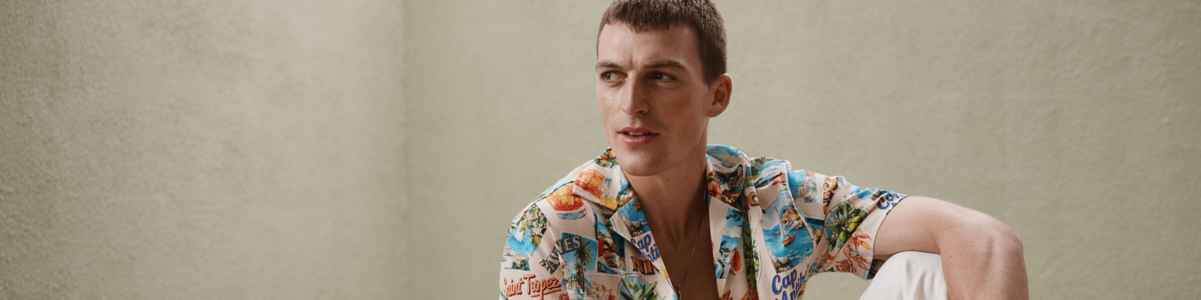 a man is wearing a colorful shirt