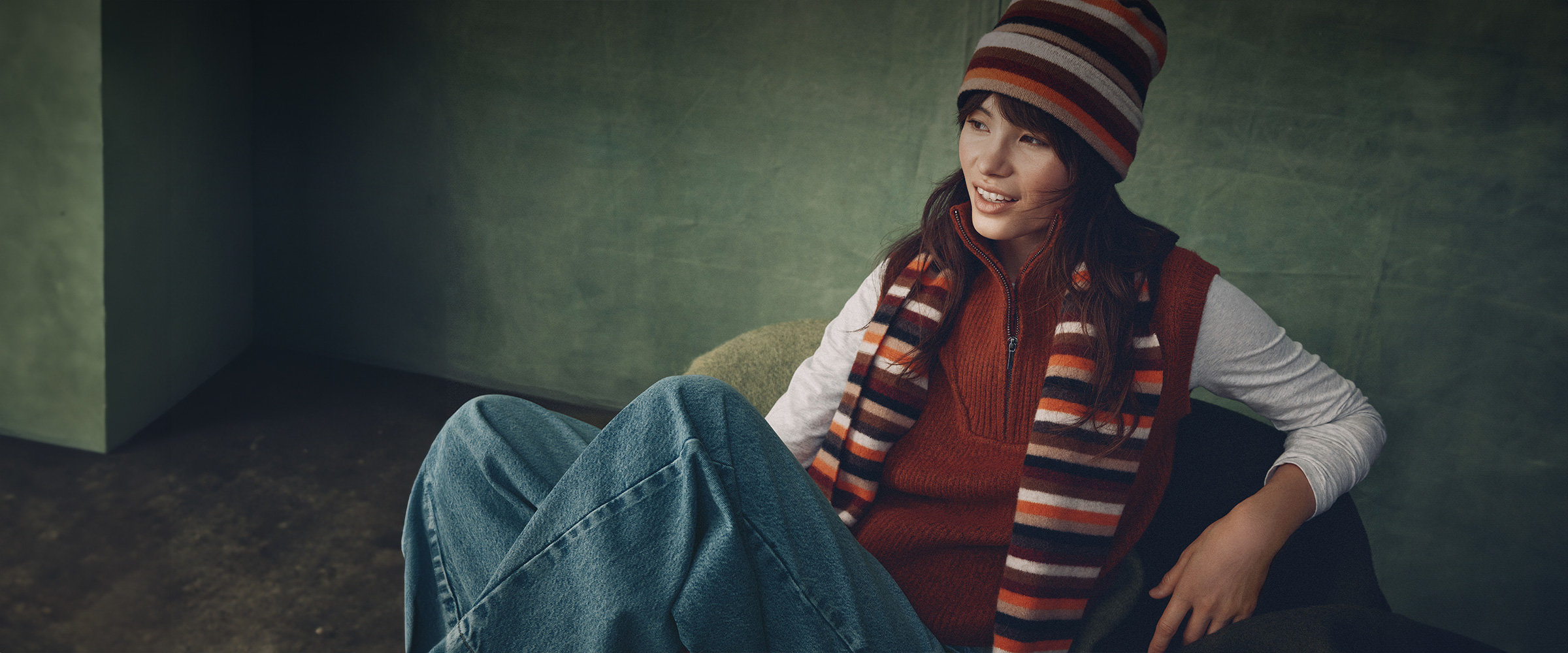 Jeune femme vêtue d'un chandail orange et d'une tuque et d'une écharpe assorties