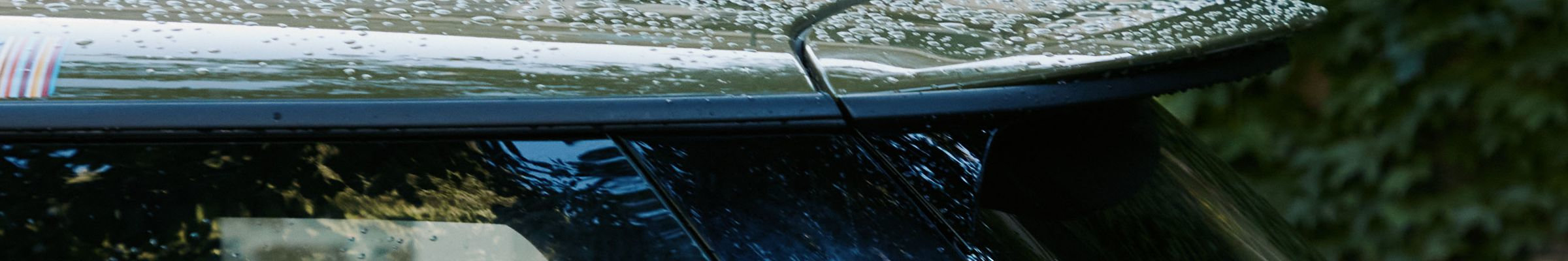 A close-up of a vehicle covered in rain drops, featuring Paul Smith's signature stripes.
