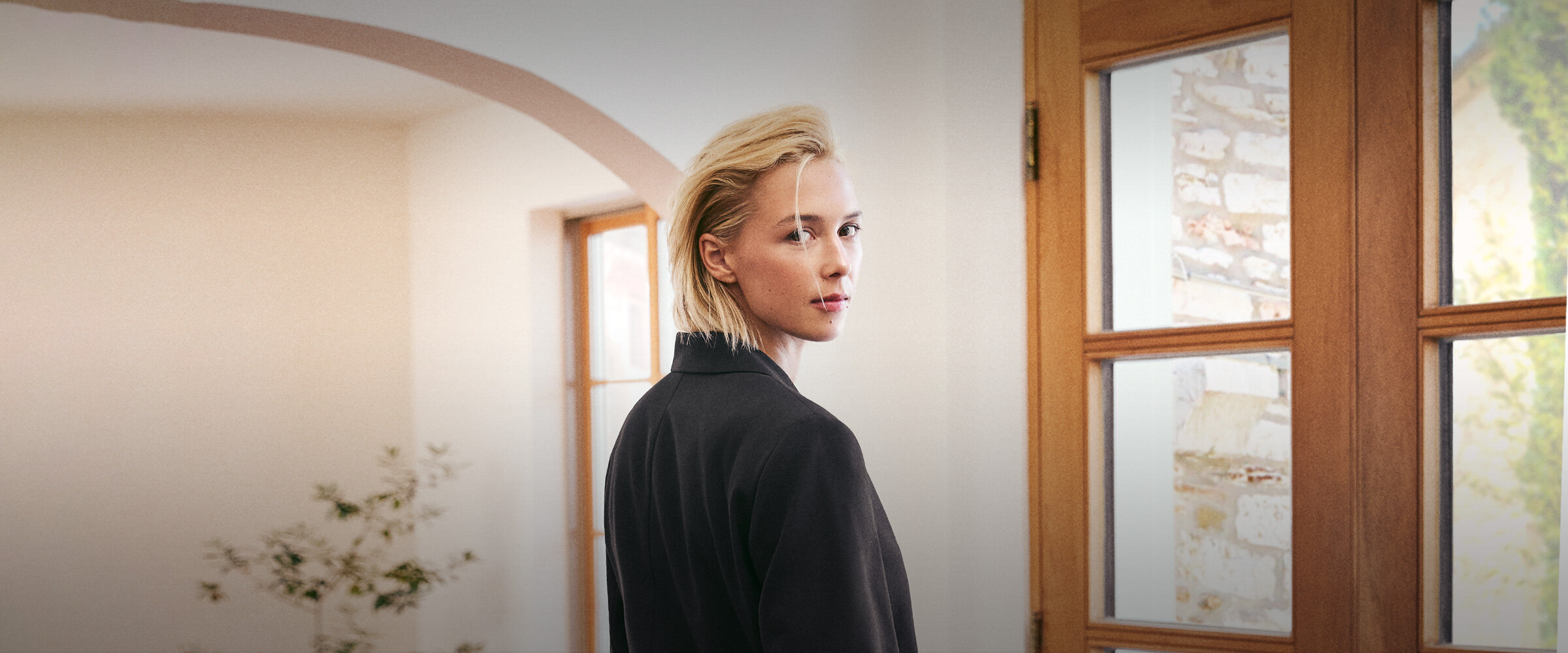 Femme vue de dos portant un veston noir de la capsule Édito par Simons