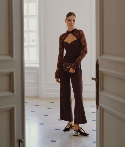 Woman wearing a jumpsuit with lace sleeves.