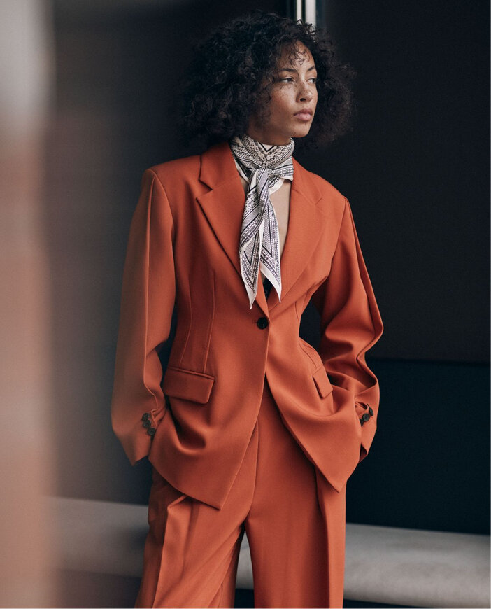 Woman wearing a burnt orange suit