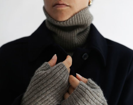 Femme portant un col roulé gris avec une surchemise noire