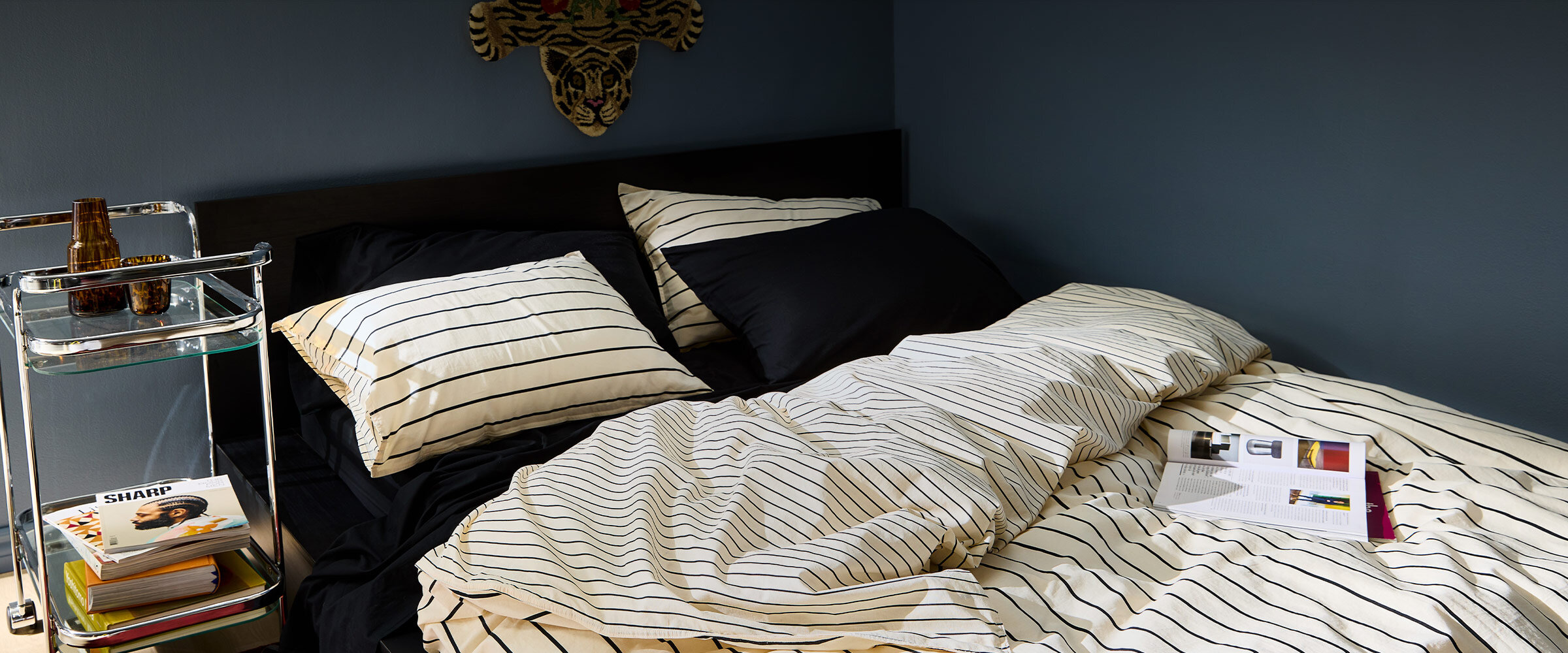 Bed with striped duvet cover and black sheets