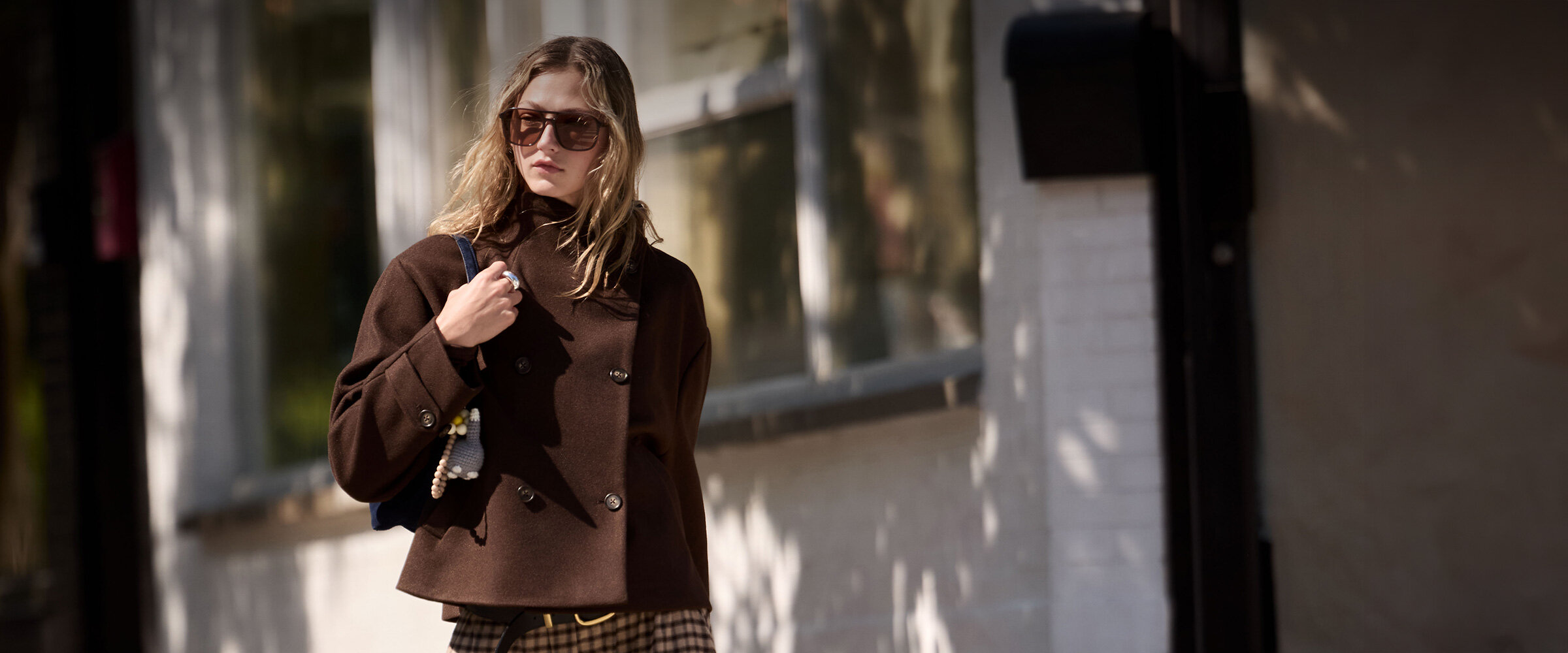 Young woman wearing a felt coat and a checkered skirt