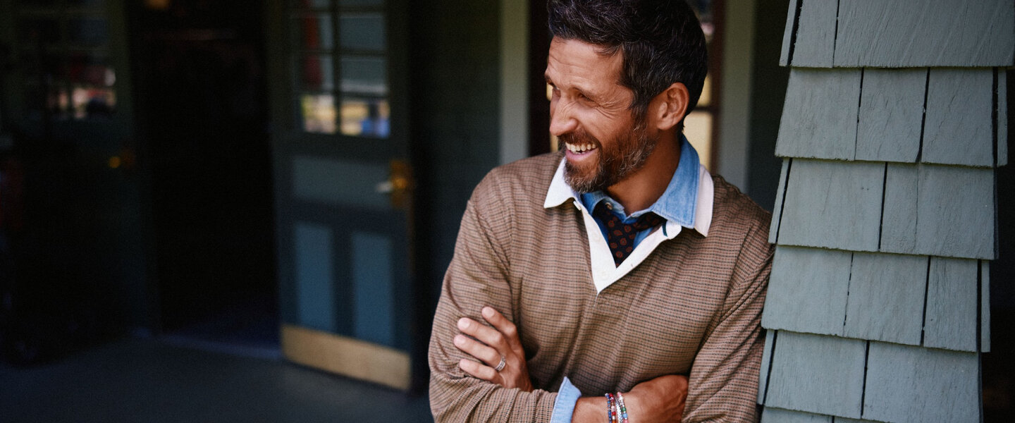 A man is wearing a brown johnny collar sweater