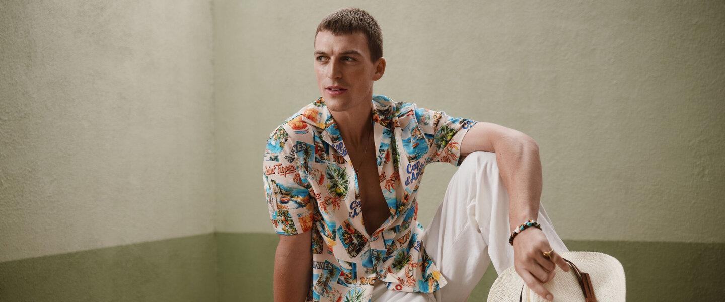 a man is wearing a colorful shirt