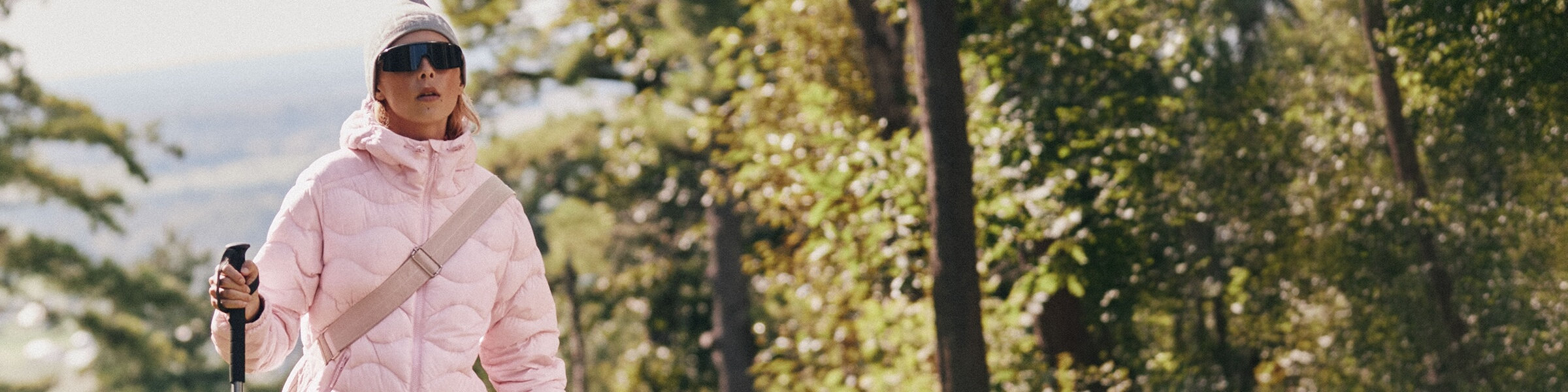 Femme dans la forêt portant un manteau matelassé et une tuque