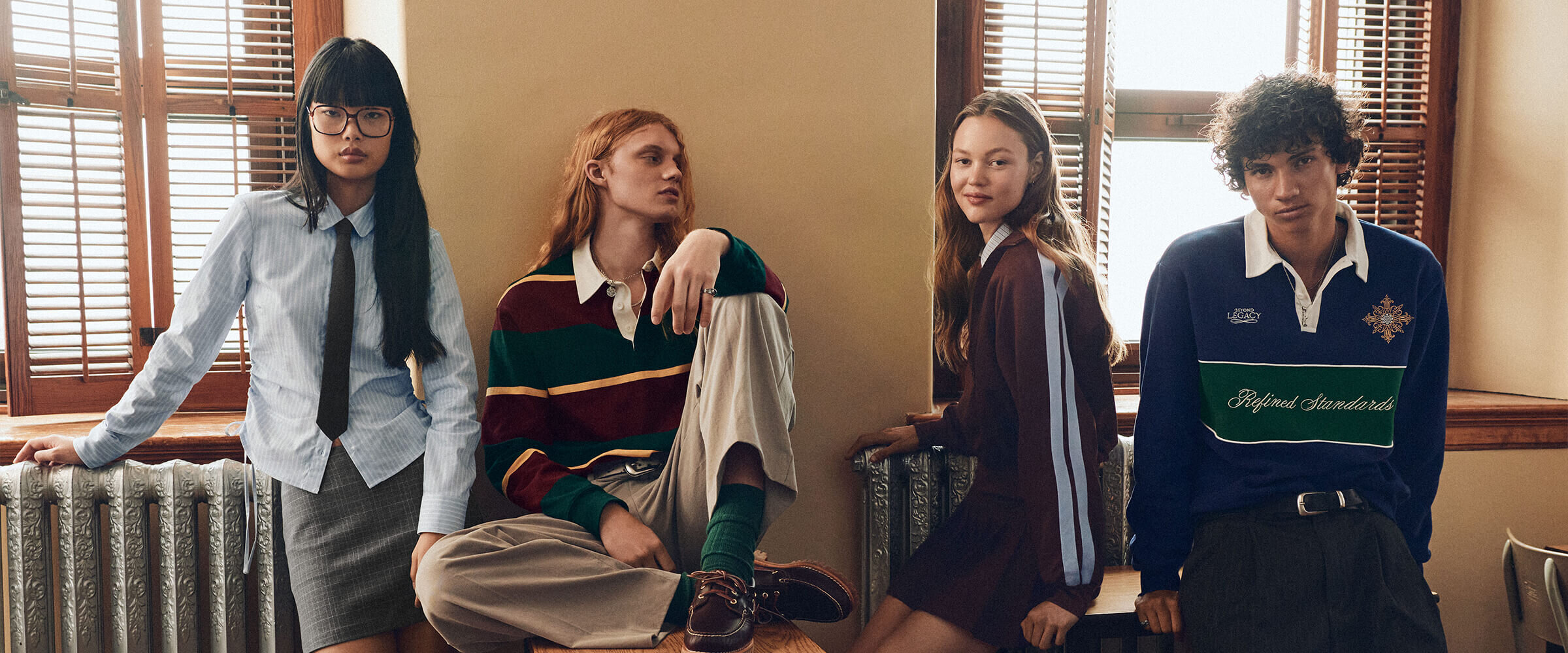 A group of two young men and two young women wearing academic-style clothing