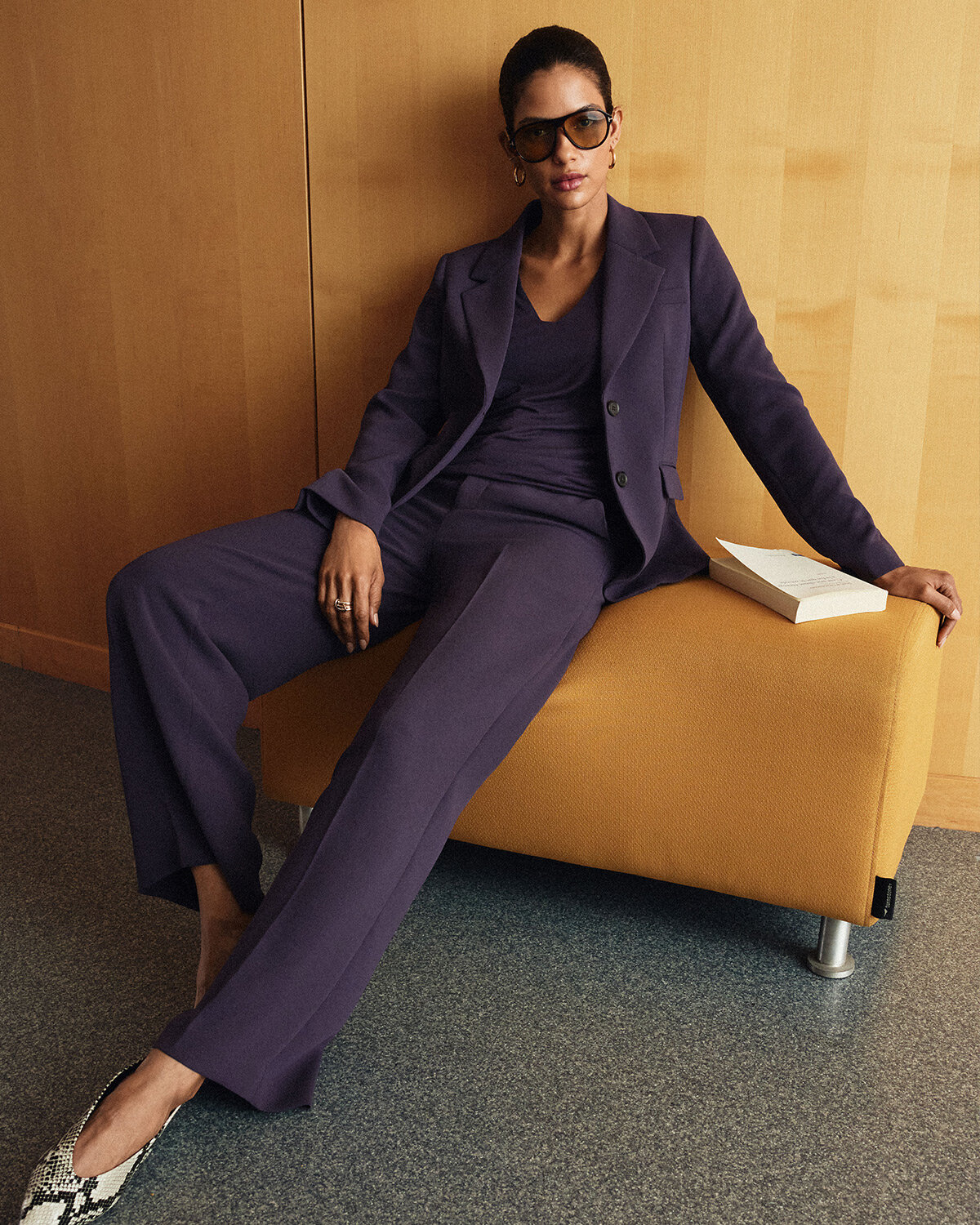 Woman wearing a dark violet suit featuring a wide-leg pant and a two-button blazer