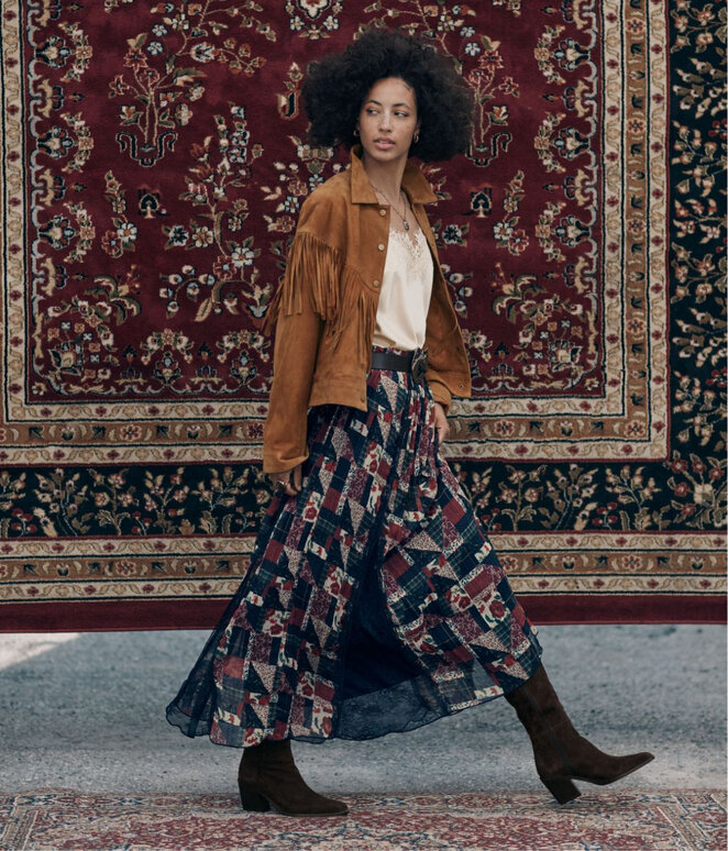 Femme qui marche portant une jupe maxi motif patchwork lisérée de dentelle