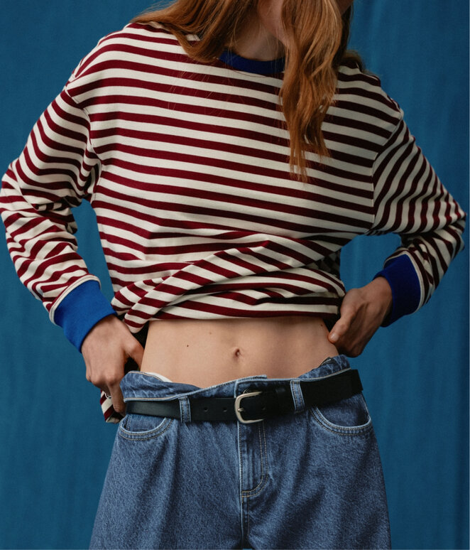 Jeune femme portant des jeans sur un fond bleu