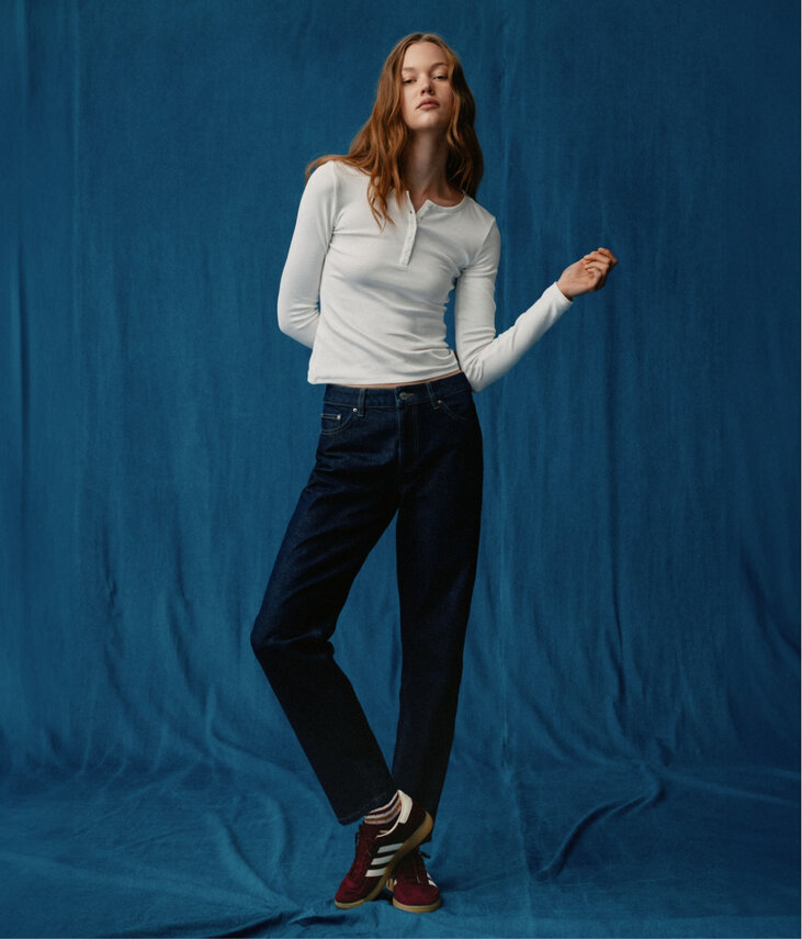 Young woman wearing jeans on a blue background