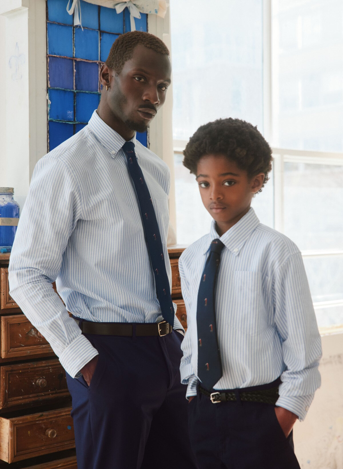 A father and his son are wearing striped shirts.