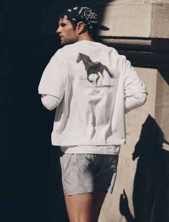 Homme qui court portant une casquette et un sweat gris