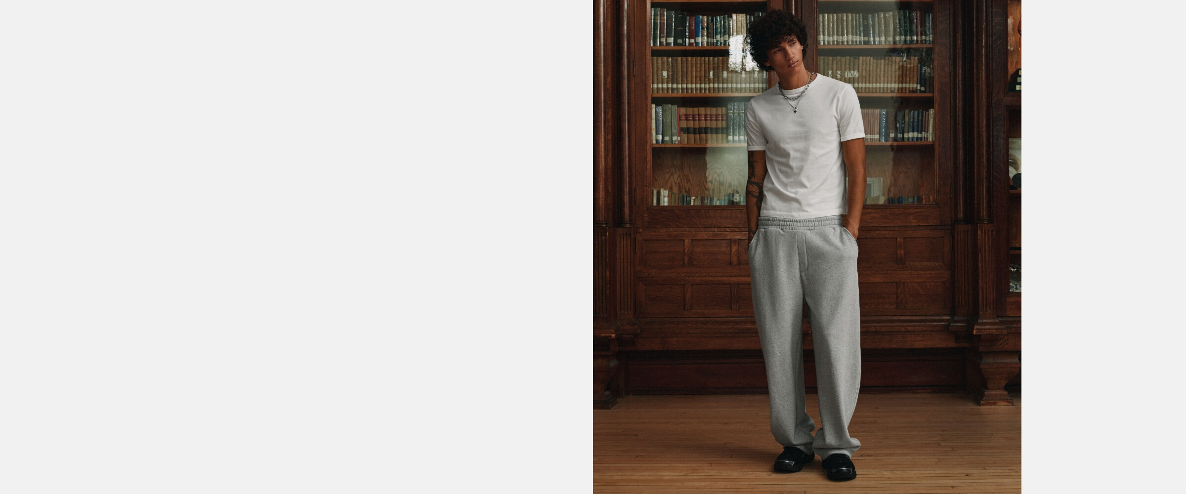 A young man wearing light grey barrel-leg sweatpants