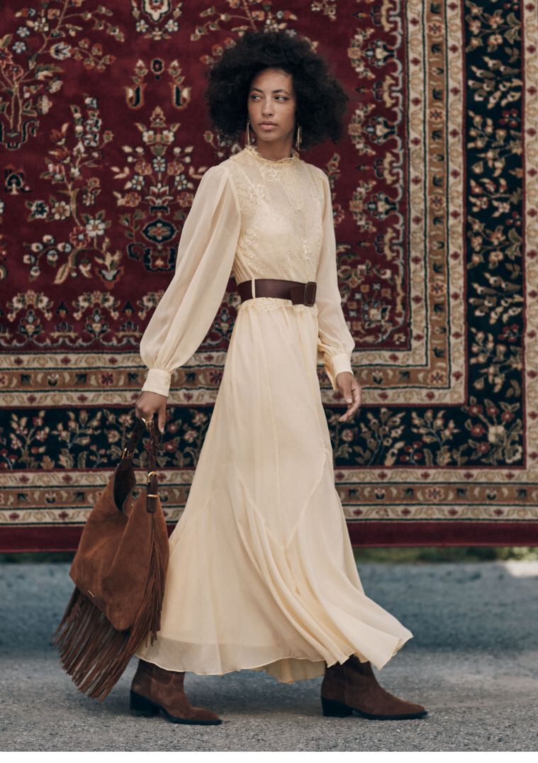 Femme portant une longue robe crème en chiffon et en dentelle