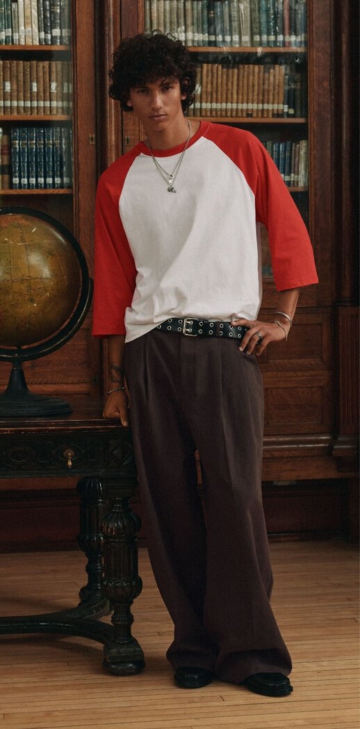 A young man wearing camouflage pants and a football jersey-style top