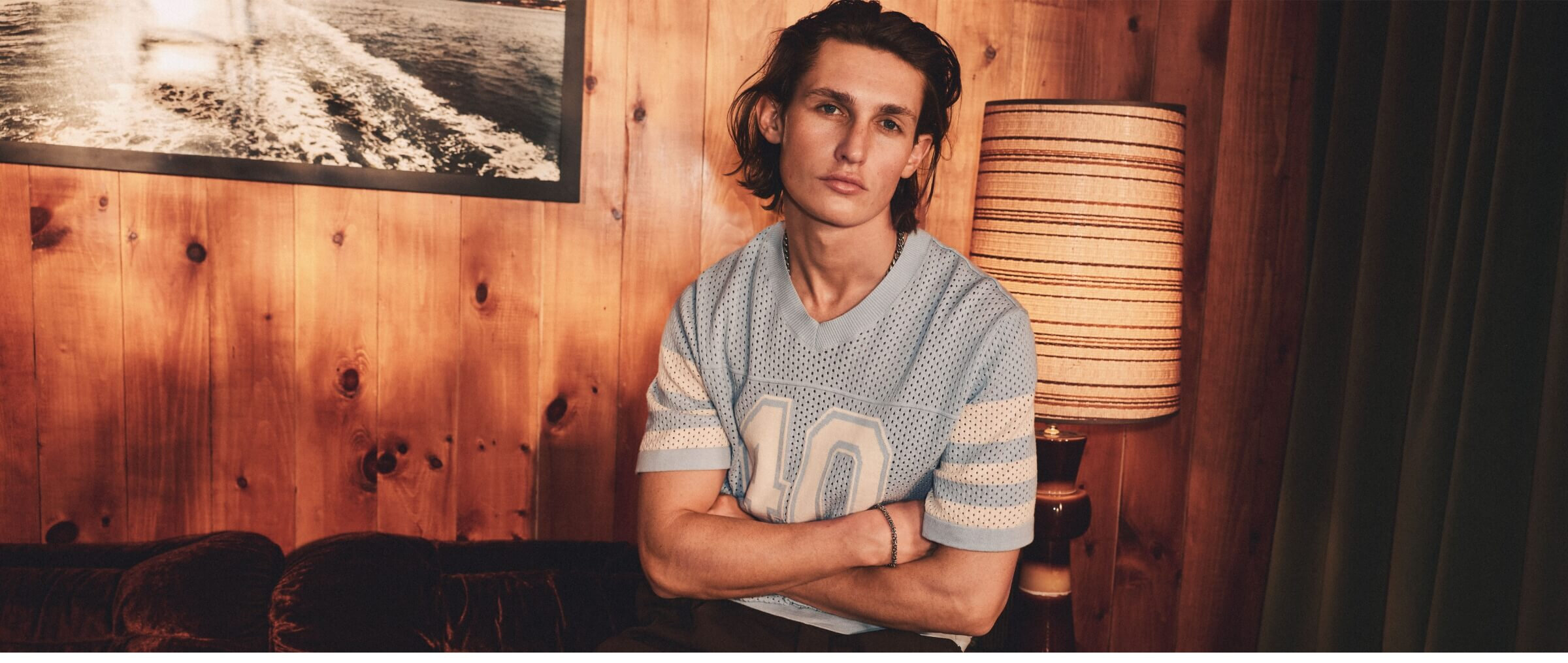 A young man wearing a mesh T-shirt similar to a sports jersey